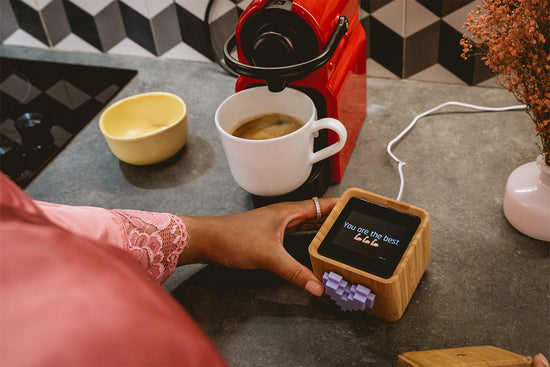 A woman reading her Lovebox message next to a cup of coffee.