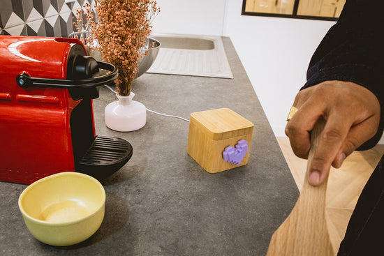 Wooden lovebox with a purple heart on the counter next to a man mixing ingredients.