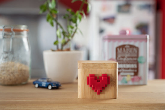 A wooden Lovebox sitting on a countertop next to a plant