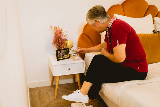 A grandmother opening a gift from her grandkids in a different state.