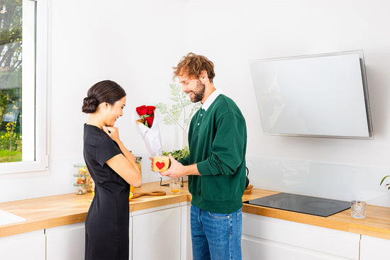 Man handing red roses to a woman.