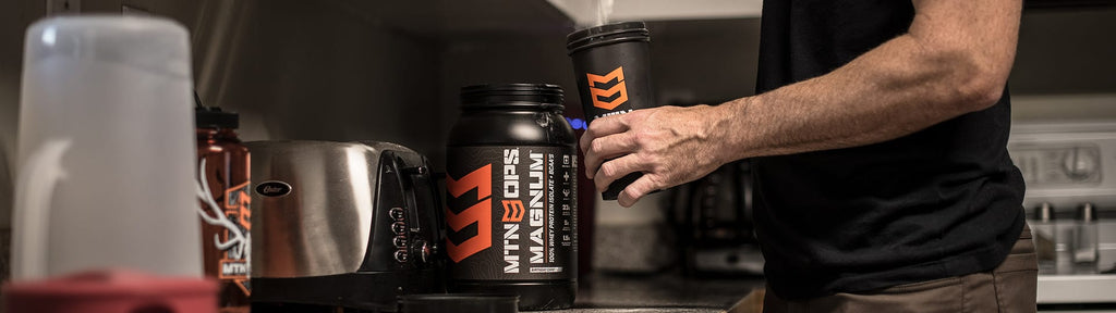 man preparing mtn ops magnum protein shake in kitchen