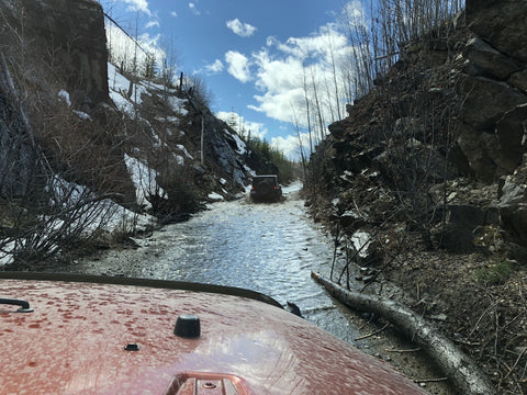 two jeeps 4x4 through deep water on dirt road