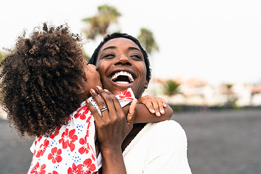 black woman hugging daughter happy