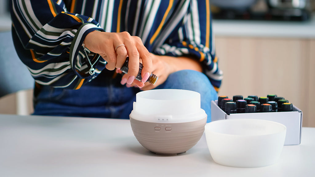 woman adding essential oils to a diffuser - spring seasonal allergy relief