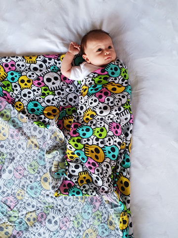 Baby half wrapped in a swaddle blanket