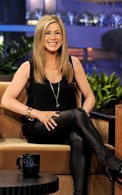 Jennifer Aniston sitting in a chair with an all black outfit on and minimal jewelry