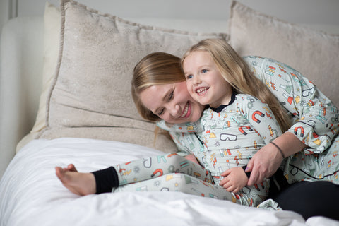 A girl and her mom wearing matching science lab bamboo pajamas