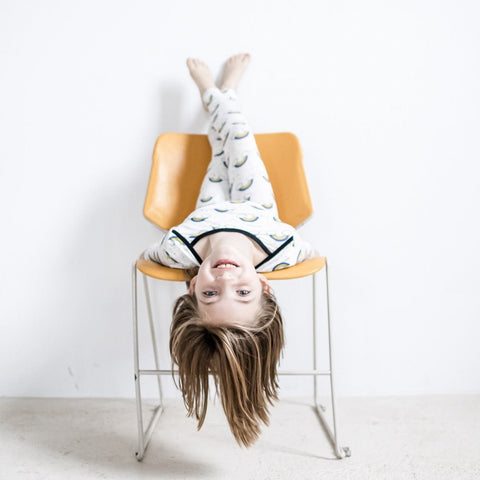 a girl sits upside down wearing bamboo pajamas