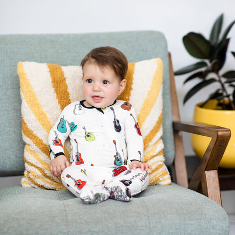 A baby wearing guitars bamboo footie pajamas