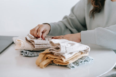 Woman folding baby clothes