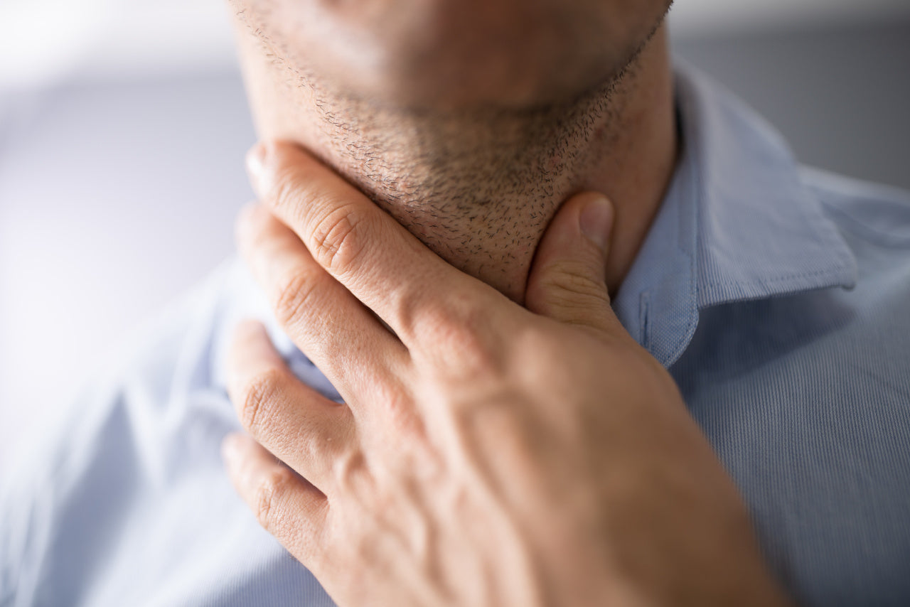 A man clutching his Thyroid Gland