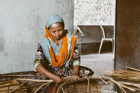 U-Chus Fair Trade - a woman artisan weaves a basket in Bangladesh