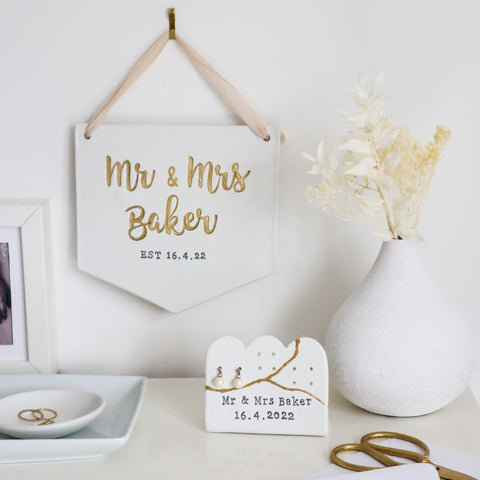 Personalised wedding keepsakes from little wisteria. A personalised mr and mrs banner and a mr and mrs earring stand sat on a beautifully styled surface
