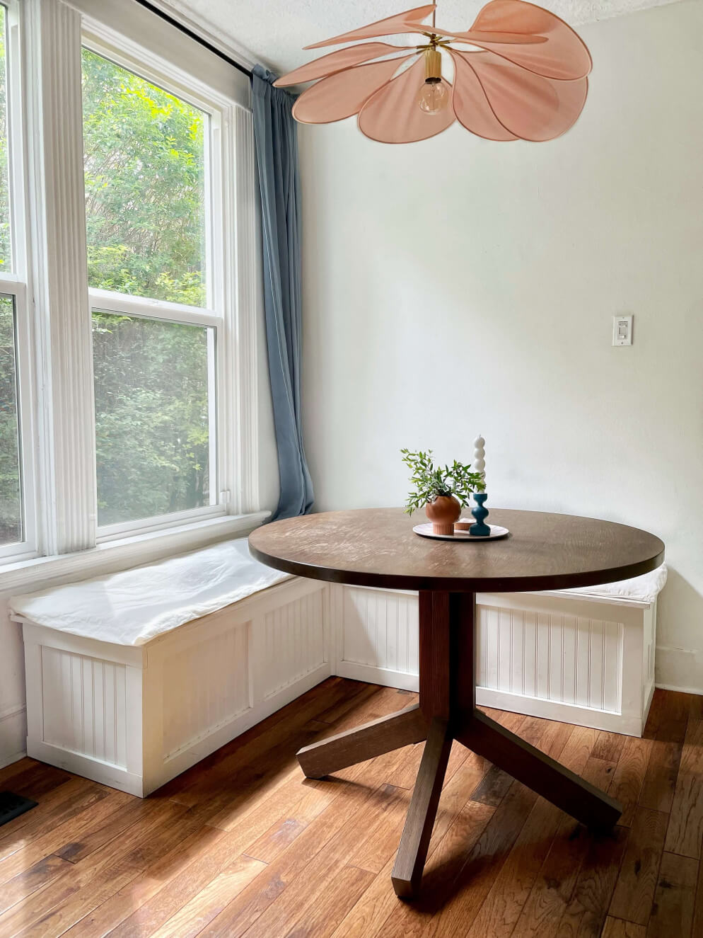 Breakfast nook with pink light and white bench