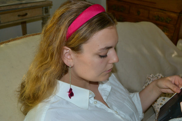 Alexis reading a magazine in the fuchsia Gelsey Fold Drop Earrings
