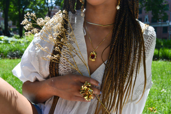 Mikayla holding a flower outside in the Lolita Necklace