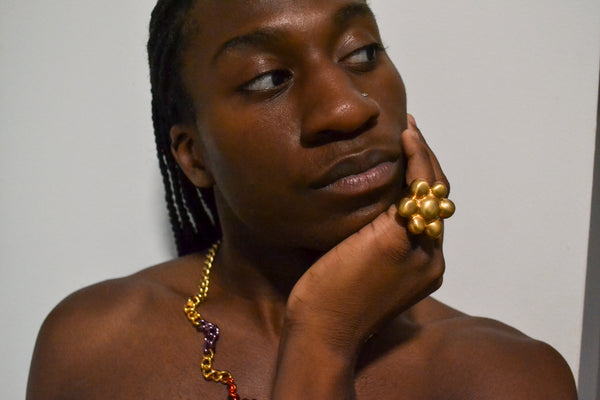 Isaiah wearing the Squiggle chain necklace, Lolita Bracelet, and Bubble ring in gold