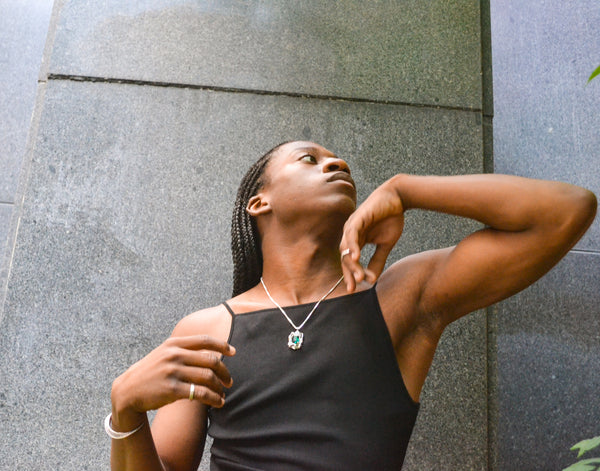 Isaiah posing outside in the Ridge Cuff and Edith Pendant Necklace