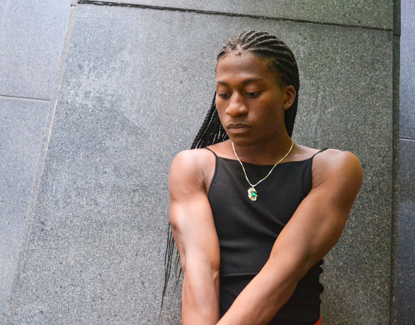 Isaiah posing outside in the Ridge Cuff and Edith Pendant Necklace