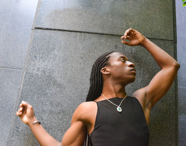 Isaiah posing outside in the Ridge Cuff and Edith Pendant Necklace