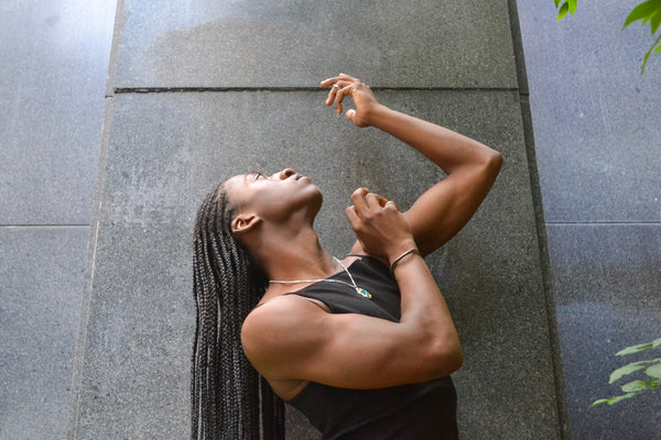 Isaiah posing outside in the Ridge Cuff and Edith pendant necklace on