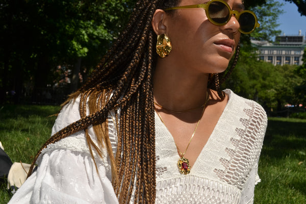 Mikayla outside wearing sunglasses and gold fold earrings