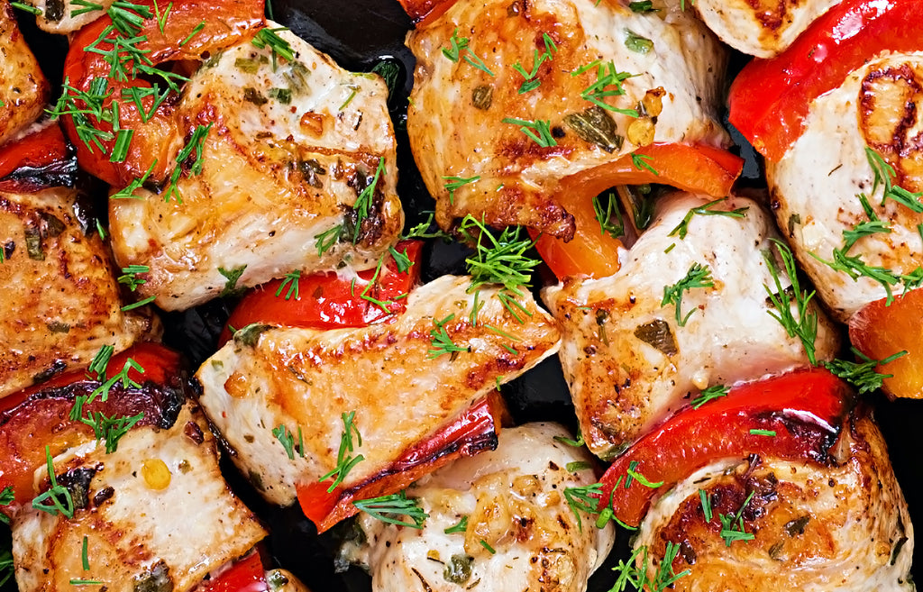 Image of grilled chicken with red pepper pieces on skewers