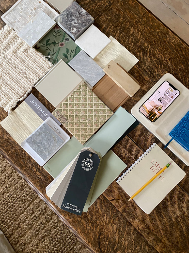 Interior designer's desk featuring color swatches, notebooks, and Courant charger