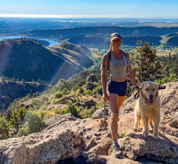 dog friendly hike in colorado girl on mountain top with dog 