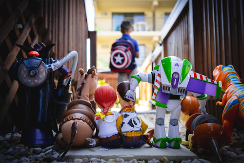 Toy Story toys stood together looking at a child leaving.