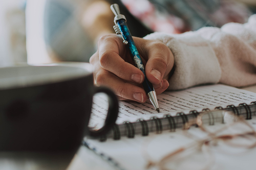 woman journaling with cup of tea