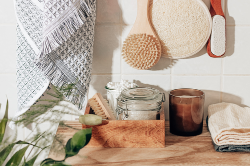 Bathroom counter with candle, cloths, and jars.