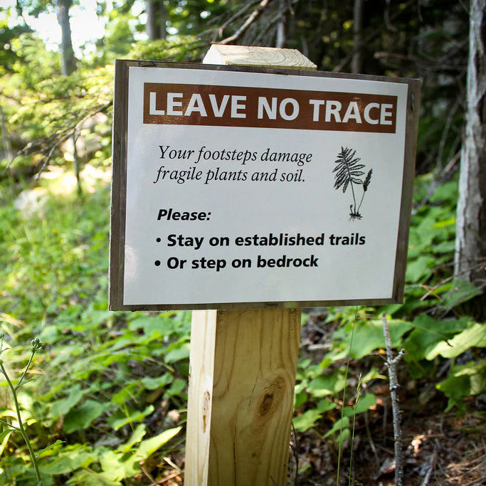 A sign on a trail that reads 