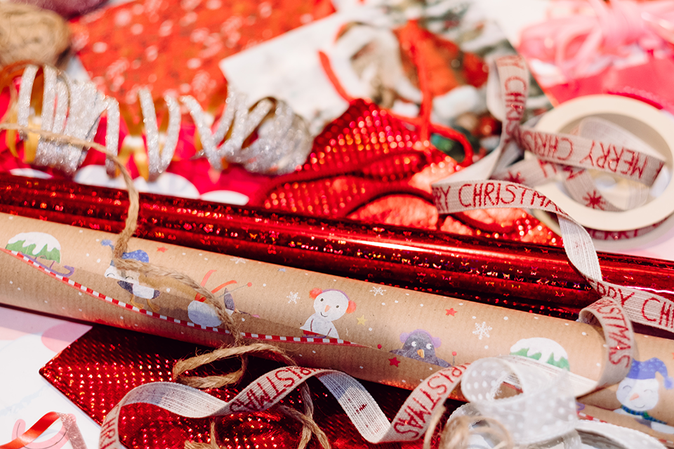Rolls of wrapping paper with ribbon strewed about