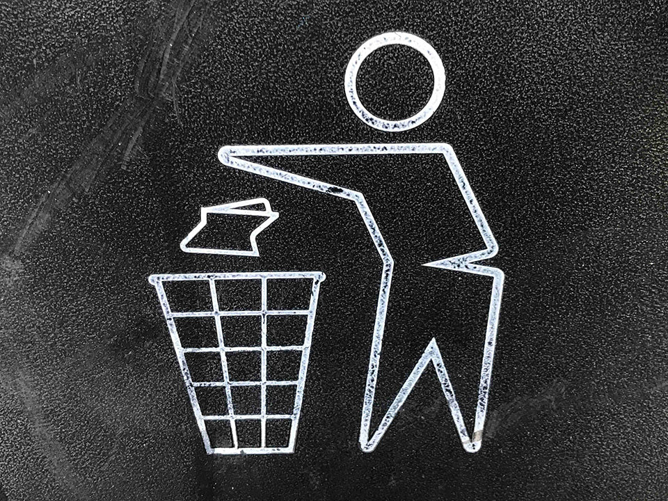 A human figure drawing drops a piece of trash/recycle into a wire bin