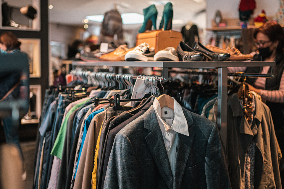 rack of clothing and shoes at a vintage second hand store