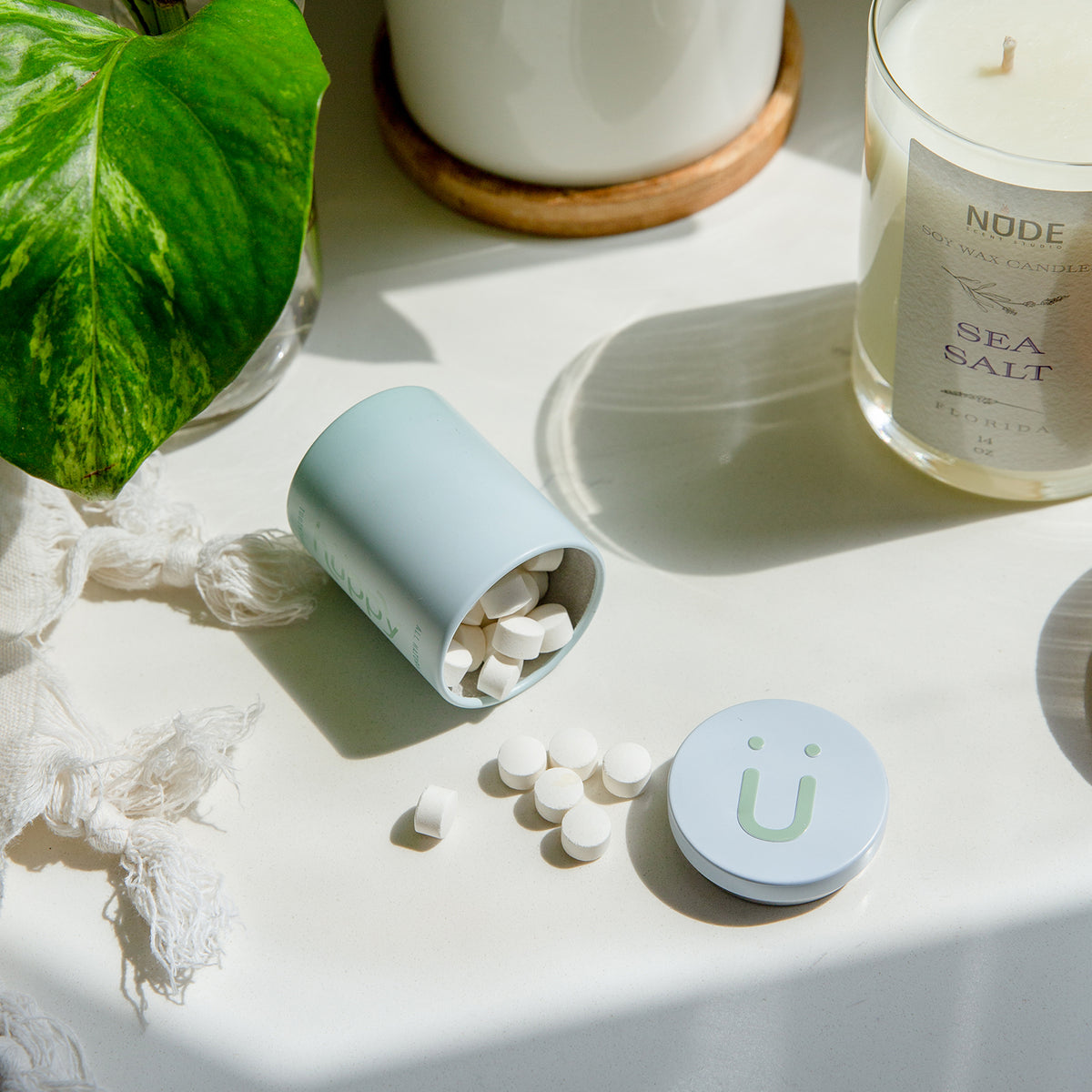 A small cylindrical tin of toothpaste tablets toppled over on a table