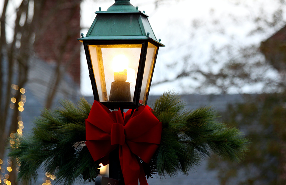 Street lamp decorated with red Christmas bow and garland