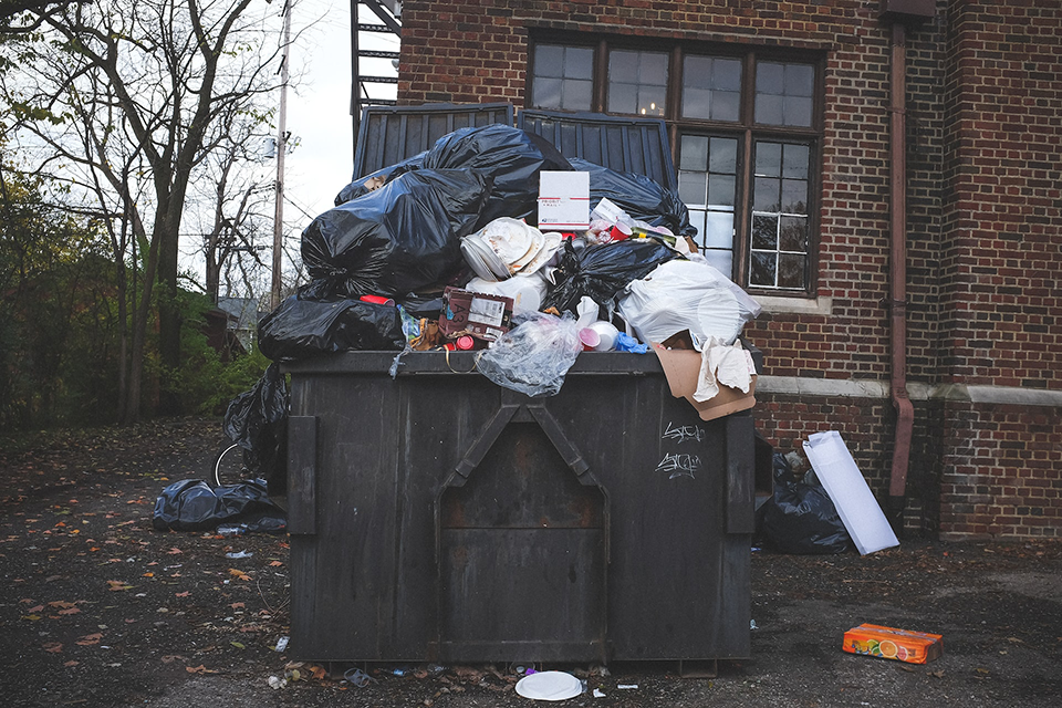 large black dumpster overflowing with trash