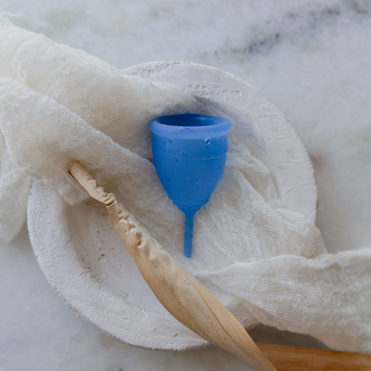 A blue Lunette menstrual cup with stem