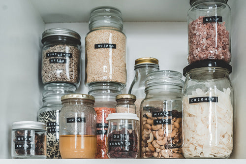 mismatched glass jars on a white shelf