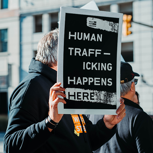 A man holding a sign in protest of human trafficking