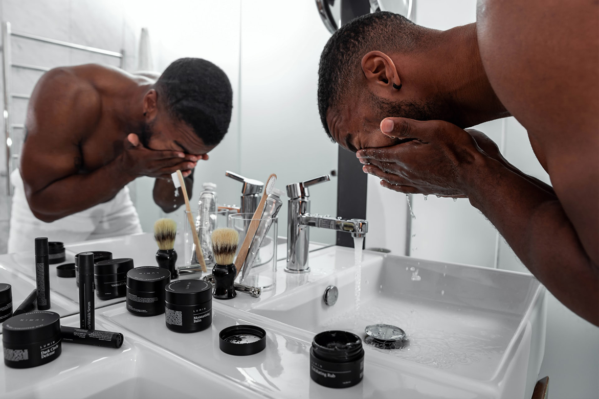 Man standing at sink washing face