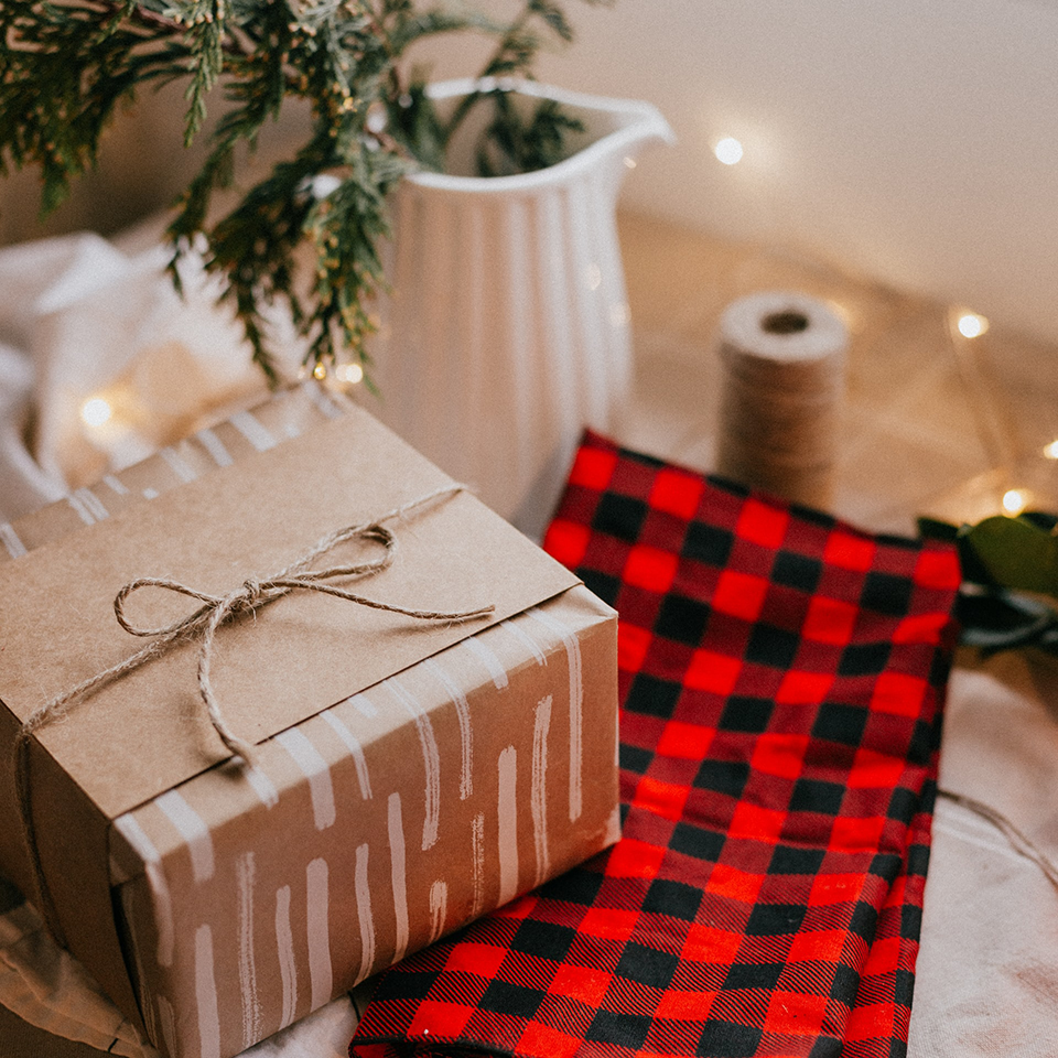 Gift wrapped in kraft paper and twine on a buffalo plaid towel