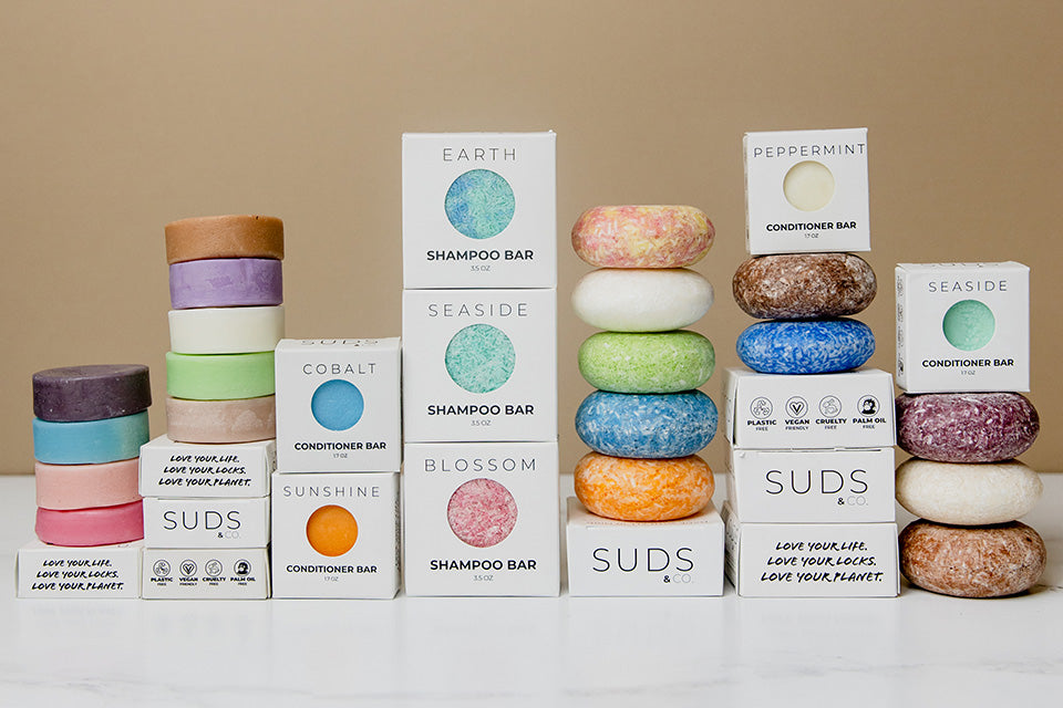 Suds & co shampoo and conditioner bars stacked with and without boxes