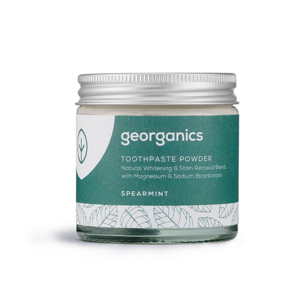 A glass jar with a sealed aluminum lid holds Georganics  Spearmint toothpowder