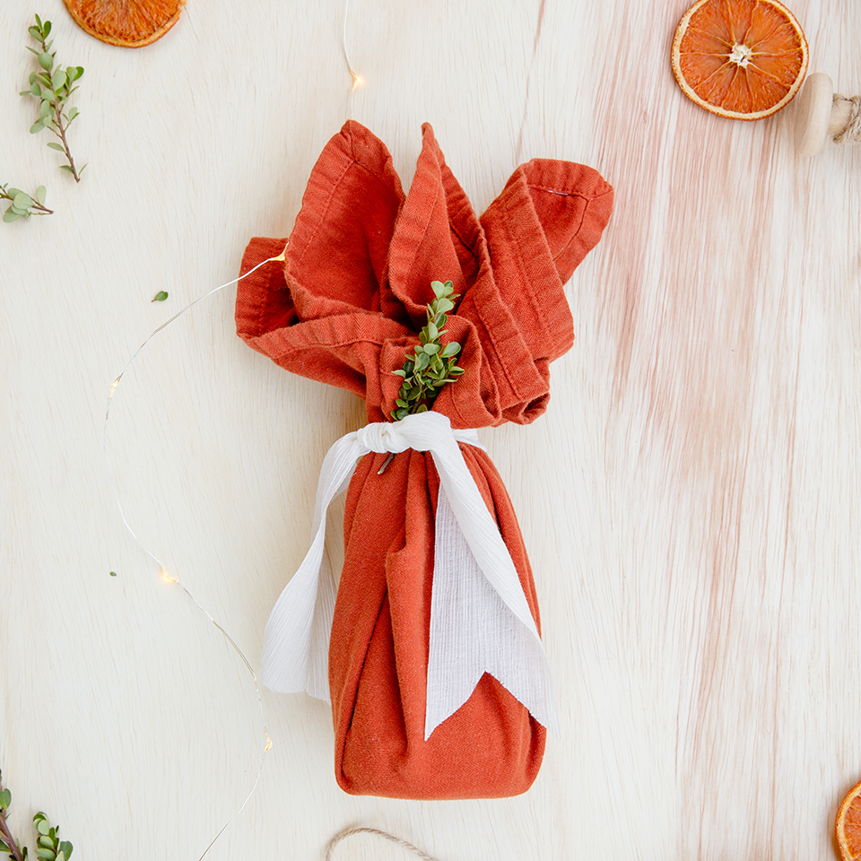 Gift wrapped in red tea towel with white linen 'ribbon'