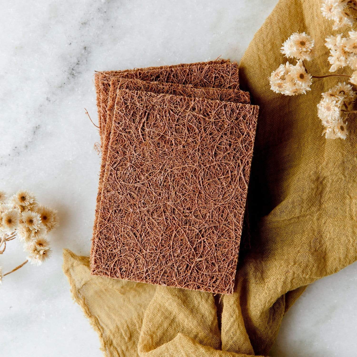 brown scrubby sponges made from coconut coir waste. Sitting on cloth on countertop