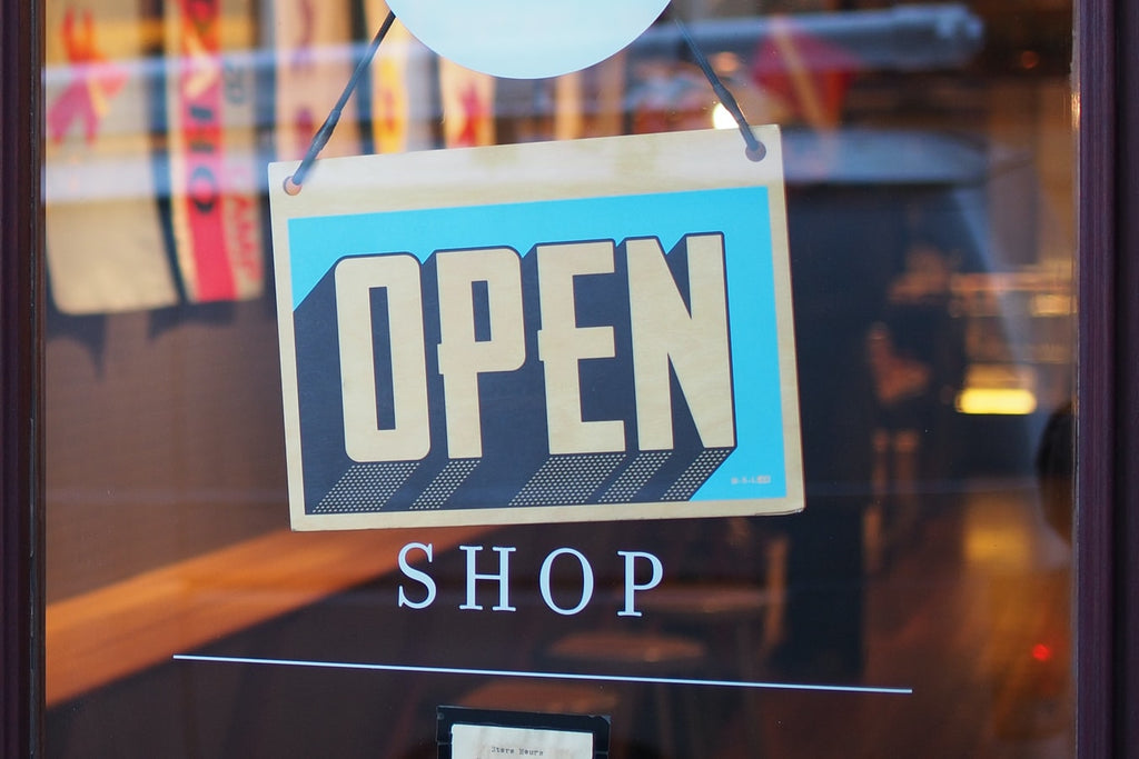 “Open” sign on glass entrance door of a business